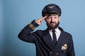 Smiling airplane captain saluting,