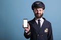 Smiling airplane captain showing modern phone