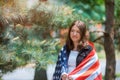 Smiling american girl holding USA flag and looking at camera independence day Royalty Free Stock Photo