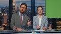 Smiling anchors talking news to audience at evening chromakey tv studio closeup Royalty Free Stock Photo