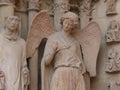 Smiling angel with beguiling smile giving a fist pump on the entrance to Notre-Dame de Reims Cathedral in France Royalty Free Stock Photo