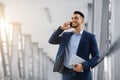 Smiling Arab Businessman Holding Digital Tablet And Talking On Cellphone At Airport Royalty Free Stock Photo