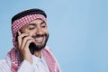 Smiling arab in ghutra talking on phone Royalty Free Stock Photo