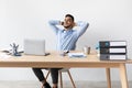 Smiling Arab man leaning back sitting at desk Royalty Free Stock Photo