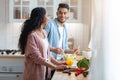 Smiling arab spouses cooking lunch in kitchen together, preparing healthy food Royalty Free Stock Photo