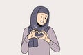 Smiling Arabic woman show heart gesture