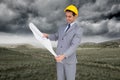 Smiling architect with hard hat looking at plans Royalty Free Stock Photo