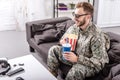 smiling army soldier in 3d glasses on couch watching movie