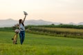 Smiling Asia woman with bicycling at the garden meadow in sunset near mountain background.