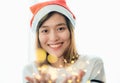 Smiling asia woman wear santa hat holding party string lights wi