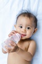 Smiling Asian baby girl drinking water from bottle Royalty Free Stock Photo