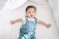 Smiling asian baby girl lying on a bed. Royalty Free Stock Photo