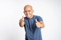 smiling asian bald man showing two thumbs up while standing
