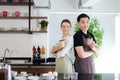 Smiling Asian barista young man and Caucasian waiter female serving two glass of hot coffee and take away to home for customers at Royalty Free Stock Photo