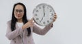 Smiling Asian business woman in eyeglasses holding clock and looking at the camera Royalty Free Stock Photo