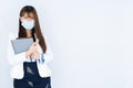 Smiling Asian business woman holding the notebook and looking at the camera over grey background. Back to the normal concept Royalty Free Stock Photo