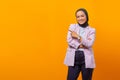 Smiling Asian business woman pointing up and looking at camera over yellow background Royalty Free Stock Photo