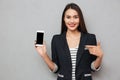 Smiling asian business woman showing blank smartphone screen Royalty Free Stock Photo