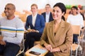 Smiling asian business woman listening to lecturer in conference room Royalty Free Stock Photo