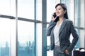 Smiling asian business woman talking on her mobile phone Royalty Free Stock Photo