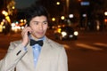 Smiling Asian businessman calling by phone on the street at night - Stock image Royalty Free Stock Photo