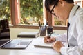 Businessman hand holding a pen writing notebook working on table at the office Royalty Free Stock Photo