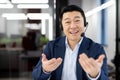 Smiling Asian businessman with headset in office Royalty Free Stock Photo