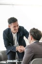 Smiling asian businessman shaking client hand, closing successful deal, satisfied hr manager hiring new employee Royalty Free Stock Photo