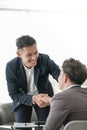 Smiling asian businessman shaking client hand, closing successful deal, satisfied hr manager hiring new employee Royalty Free Stock Photo