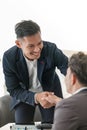 Smiling asian businessman shaking client hand, closing successful deal, satisfied hr manager hiring new employee Royalty Free Stock Photo