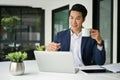 Smiling Asian businessman working on his business task in laptop computer at his desk Royalty Free Stock Photo