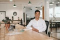 Smiling Asian businessman working at his desk in an office Royalty Free Stock Photo