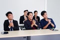 Smiling Asian businesspeople are clapping and having a seminar in the economics class in meeting room. Collegians are learning Royalty Free Stock Photo