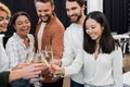 Smiling asian businesswoman clinking champagne with Royalty Free Stock Photo