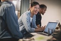 Smiling Asian businesswoman meeting with coworkers in an office