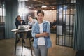 Smiling Asian businesswoman in an office with colleagues behind Royalty Free Stock Photo