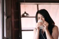 Smiling Asian businesswoman is relaxing and drinking a cup of hot coffee in coffee shop Royalty Free Stock Photo