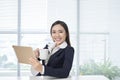 Smiling asian businesswoman sitting in bright office Royalty Free Stock Photo