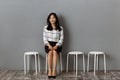 smiling asian businesswoman sitting on chair while waiting