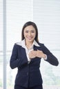 Smiling asian businesswoman standing in bright office Royalty Free Stock Photo