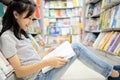 Smiling asian child girl sitting reading a book on the floor,teenage student searching in formation in textbook for coursework Royalty Free Stock Photo