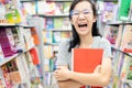 Smiling asian child girl wearing glasses holding a book on her arms,female student standing feel enjoy in book store,happy woman Royalty Free Stock Photo