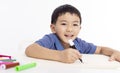 Smiling asian child schoolboy studying and drawing at home