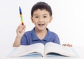 Smiling asian child schoolboy studying and drawing at home