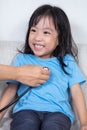 Smiling Asian Chinese little girl examine by doctor with stethoscope