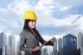 Smiling asian contractor woman with yellow helmet holding clipboard Royalty Free Stock Photo