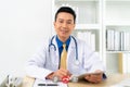Smiling Asian doctor with digital tablet looking at camera. Remote online medical chat consultation, tele medicine distance Royalty Free Stock Photo