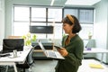 Smiling asian female architect with laptop and smart phone in creative office Royalty Free Stock Photo