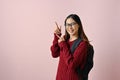 Smiling Asian female college student pointing her fingers, showing right or correct hand gesture Royalty Free Stock Photo