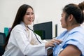 Smiling Asian female doctor cardiologist examining fat woman cardiac patient listening checking heartbeat Royalty Free Stock Photo